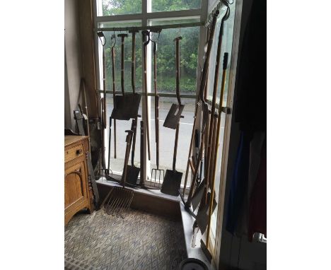 A collection of assorted vintage garden tools, including shovels, spades, pick axe, etc. 