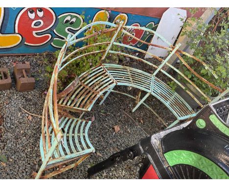 A decorative painted arch shaped garden bench. 