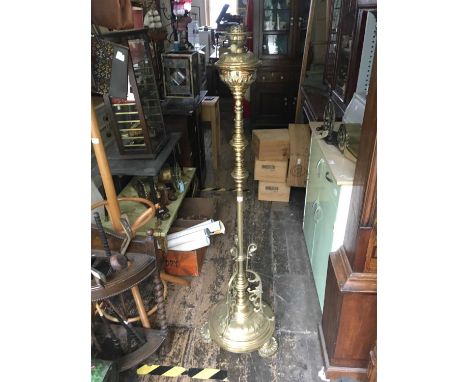 A Victorian brass adjustable oil lamp with repoussé floral decoration on cast circular plinth base, height 148cm. 