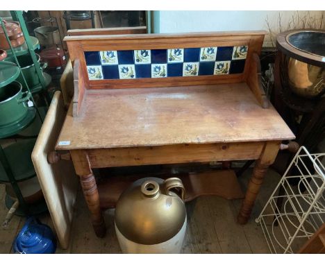 An old pine wash stand with tiled back and undertier shelf, width 95cm, depth 46cm, height 86cm.