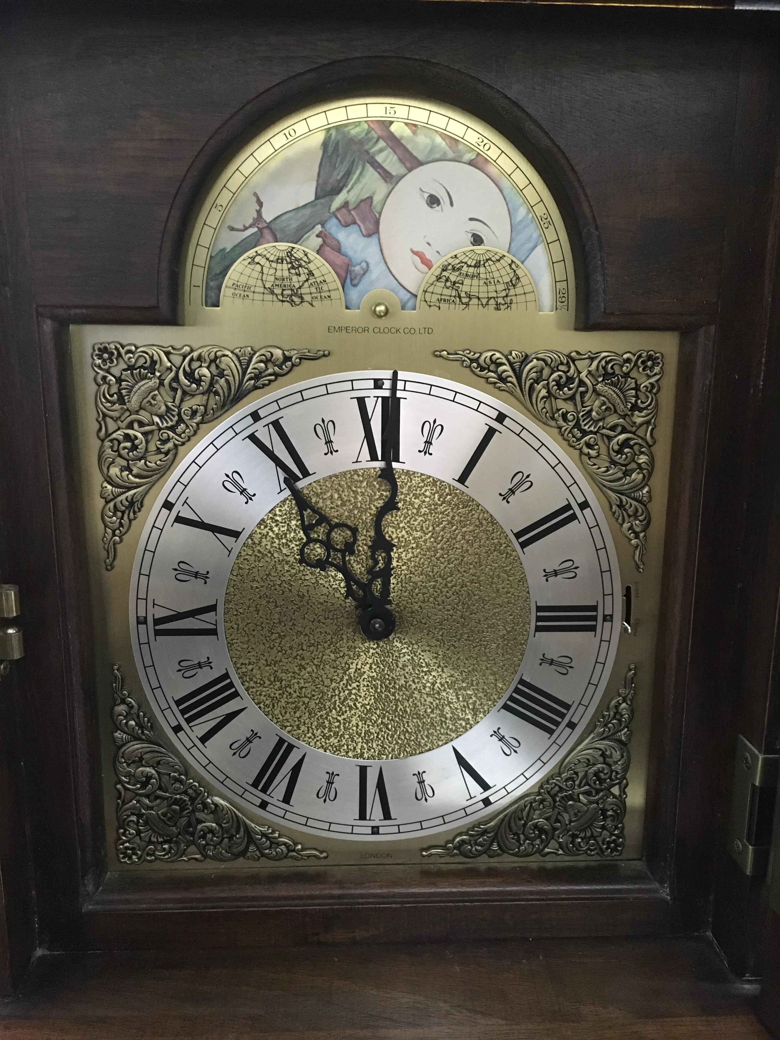 A reproduction grandmother clock with rotating dial depicting ships