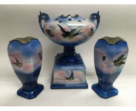 A garniture of ceramic vases decorated with birds on a blue ground, central piece approx 31cm.