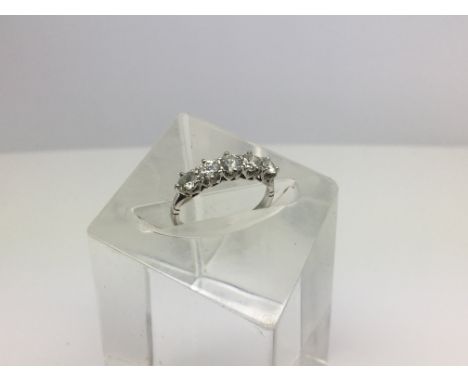 A white metal ring, possibly platinum, with a row of five brilliant cut diamonds each .2ct (1ct total). Ring size K-L.