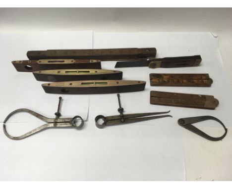 A group of vintage tools to include spirit levels, rulers and callipers.