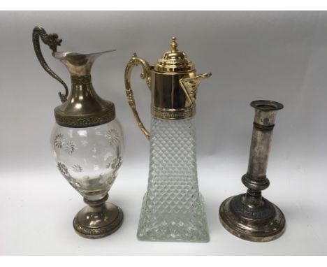 A pair of glass claret jug decanters and a silver plated candlestick.