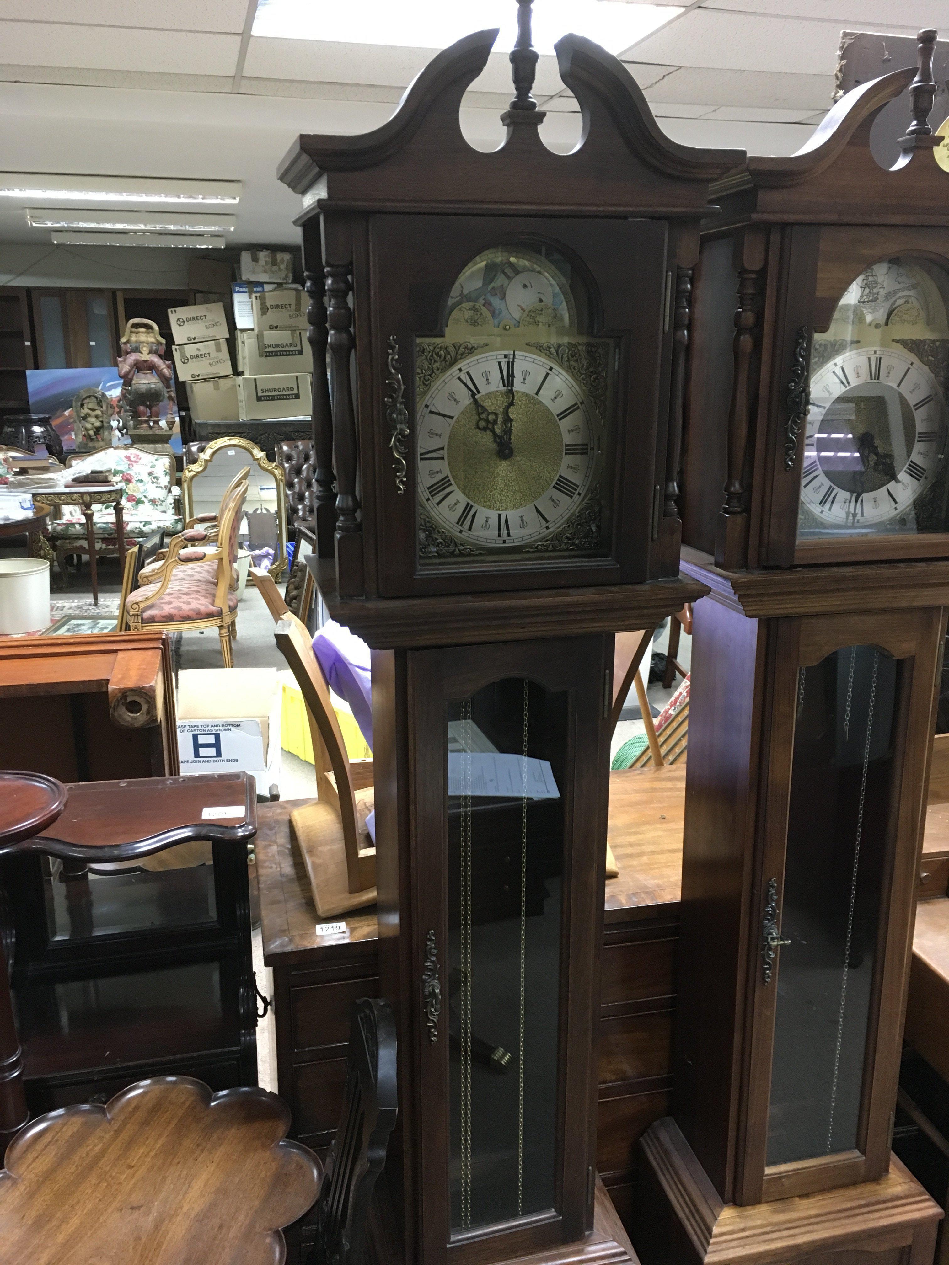 A reproduction grandmother clock with rotating dial depicting ships