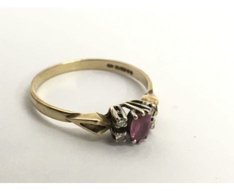 A 9ct gold ring set with ruby or possible pink sapphire flanked by diamonds.Approx Q/R