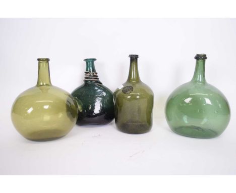 Group of four 18th century green glass bottles including a Pyrmont water bottle with seal, two further olive green examples a