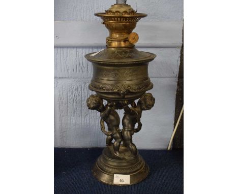 Oil lamp, the lamp decorated with cherubs in spelter, on raised circular base, 30cm high