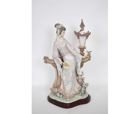 Large Lladro model of a geisha standing against a lamp, on a shaped wooden base, 40cm high