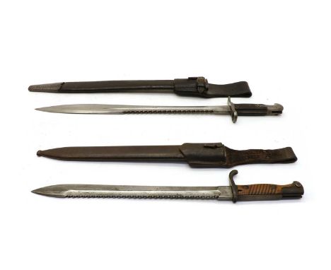 Two WWl saw back bayonets in scabbards, the first for a British pattern 1875 Henry rifle, 64cm long overall, the second inscr