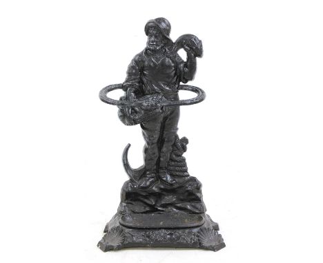 A cast-iron stick stand in the form of a fisherman, late 19th Century, with detachable drip pan, and shell carved base, cast 