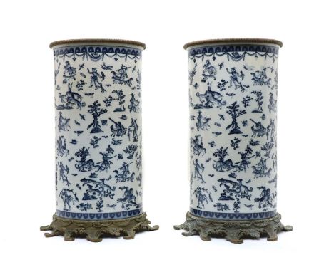 A large pair of porcelain stick stands, possibly French, 20th century, decorated with figures and animals, with metal mounts 