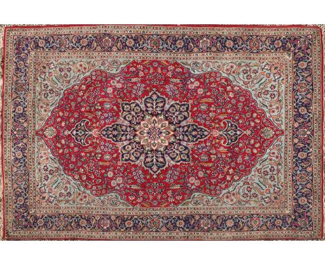 A Kirman carpet, with central medallion to a red field, 377 x 244cmCondition report: Losses to tassels. General wear. In need