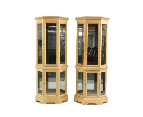 A pair of contemporary light oak display cabinets, each with bevelled glass panels and internal lighting, 75cm wide, 34cm dee