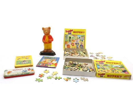 An assortment of Rupert the bear annuals and jigsaws, the annuals dating from 1969 onwards, together with a figural lampCondi