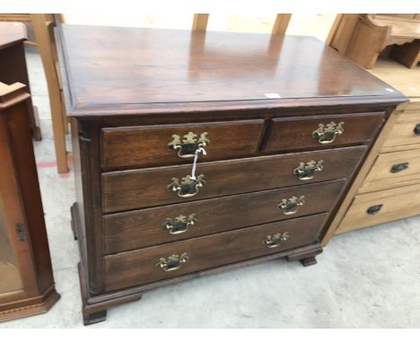 AN OAK CHEST OF TWO SHORT AND THREE LONG DRAWERS WITH ORNATE BRASS HANDLES ON BRACKET FEET 