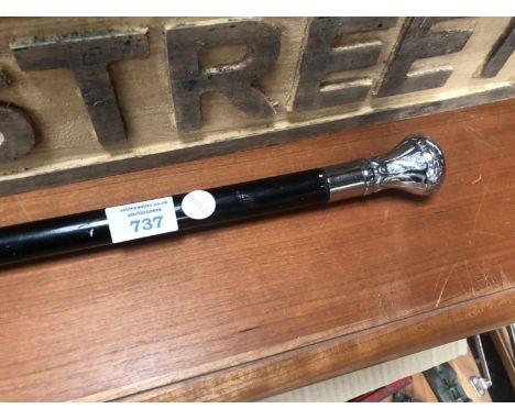 A WOODEN WALKING STICK WITH METAL TOP 