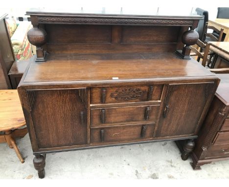 AN OAK SIDEBOARD ON BALUSTER SUPPORTS WITH TWO DOORS, THREE DRAWERS AND UPPER SPLASHBACK SHELF 