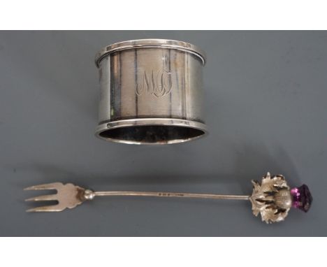 An Edwardian silver pickle fork, the terminal modelled as a thistle and set with an amethyst coloured stone, 12 cm, together 