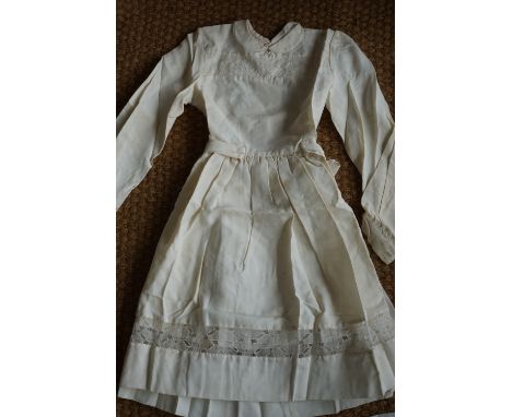 A 1920s girls dress, having a Peter Pan collar, full length sleeves with button cuffs, integral ribbon-bow waist belt and ple