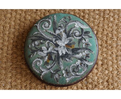 A Victorian beadwork-upholstered mahogany pad stool with white ceramic bun feet, 26 cm