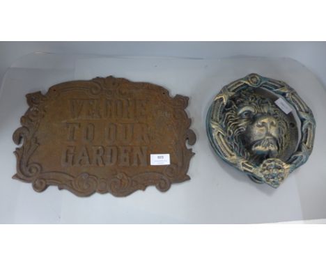 A cast iron Welcome To Our Garden sign and a cast iron Lion's head door knocker 