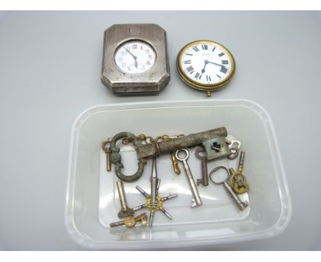 A silver pocket watch travel case, lacking back stand, with top wind pocket watch, an 8 Days clock, a/f, keys, etc. 