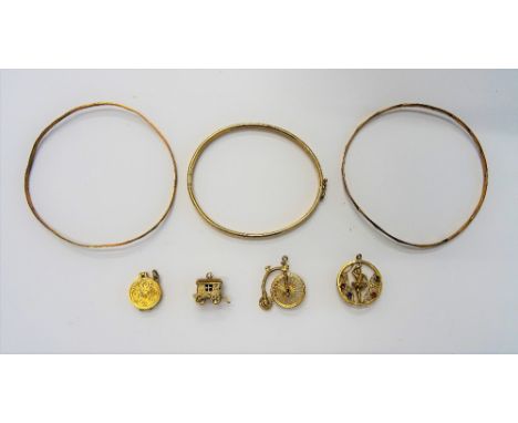 Four 9ct gold charms, comprising; a dart board, a penny farthing bicycle, a traveller's caravan and a gem set ballerina, a 9c