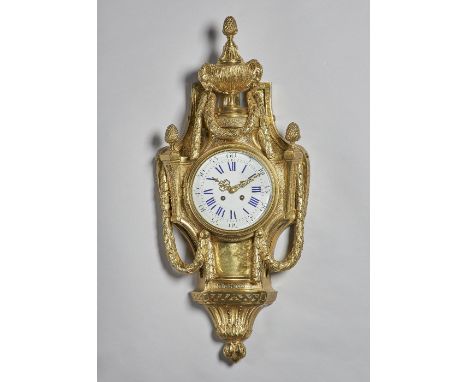 A French giltmetal Cartel clockIn the Louis XVI style, circa 1900Surmounted by a berried finial and urn with ram's mask and l