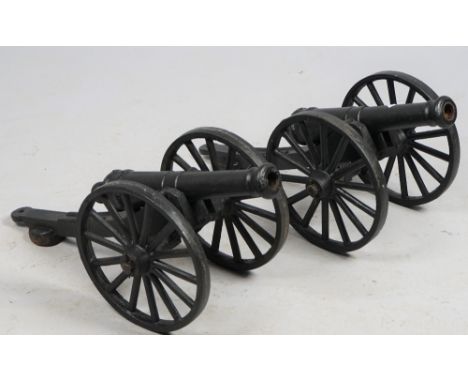 A pair of modern cast iron scale model cannon, each with spoked wheels and turned barrel, 71cm, (2). 