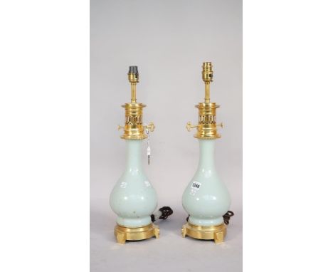 A pair of Chinese style celadon porcelain vase table lamps, late 20th century, each with gilt metal faux oil lamp mounts, 40c