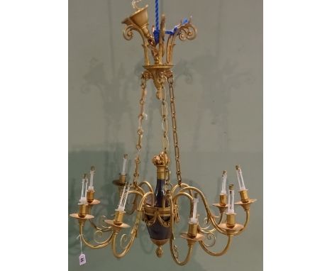 An ebonised and gilt brass Empire style nine branch chandelier, 20th century, the urn shaped body issuing nine swan neck bran