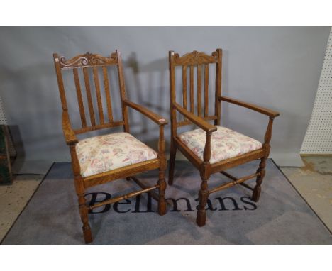 A pair of mid-20th century oak open armchairs with stick backs on block end turned supports, 57cm wide x 105cm high. 