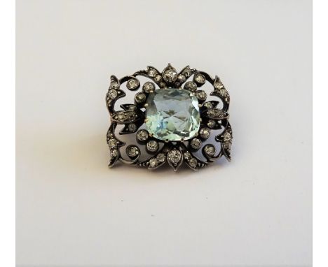 A gold backed and silver fronted aquamarine and diamond brooch, mounted with the cushion shaped aquamarine at the centre, wit