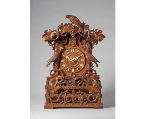 A Tyrolean carved walnut striking fusée cuckoo mantel clockBy Aron Ketterer, Furtwangen, late 19th centuryIn an architectural