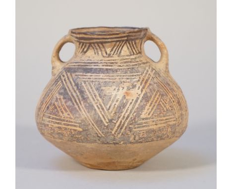 A small Chinese red earthenware two-handled vase, Neolithic period, circa 3rd century BC, painted with a stylised design, 13c