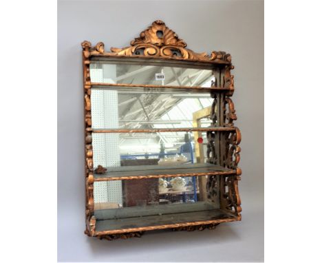 A Victorian gilt hanging waterfall four-tier wall shelf with pierced sides and mirror back, 50cm wide x 72cm high. 