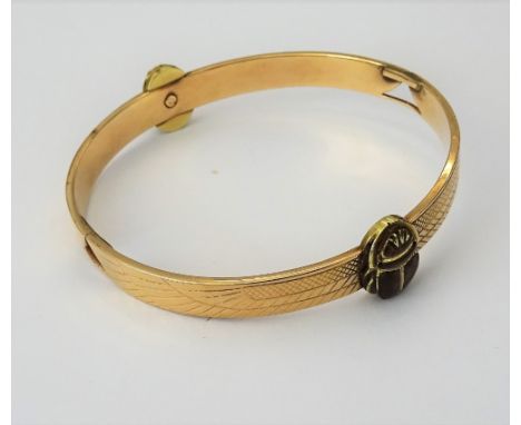 A gold and pale brown enamelled bangle, formed as two scarabs with wings, the two scarab bodies having pale brown enamelled d