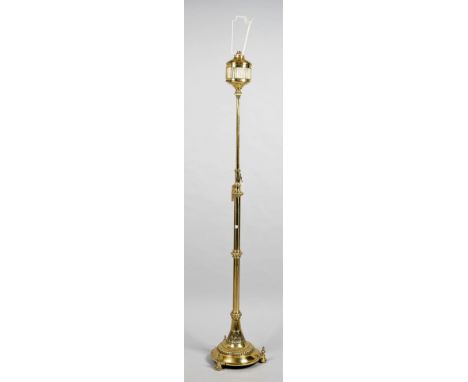 A gilt metal mounted brass standard lamp, early 20th century, with adjustable top over a circular base and three pad feet. 