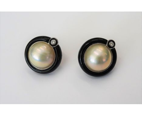 A pair of black jade, diamond and cultured pearl earclips, the mabé pearls collet set in a surround of carved black jade, abo