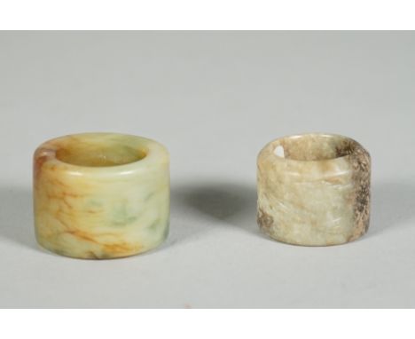 A Chinese jade archer's ring, Qing dynasty, carved with two deer, the stone of greyish green tone with black inclusion, 3cm. 