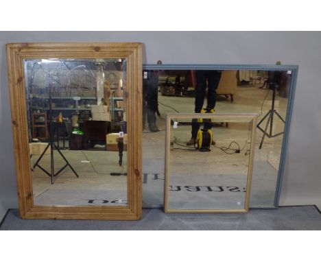 An early 20th century rectangular pine mirror with bevelled glass 78cm wide x 107cm high, a 20th century blue painted wall mi