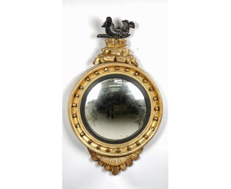 A Regency gilt framed convex mirror with unusual serpent surmount and starburst lower about the reeded ebonised slip, 67cm wi