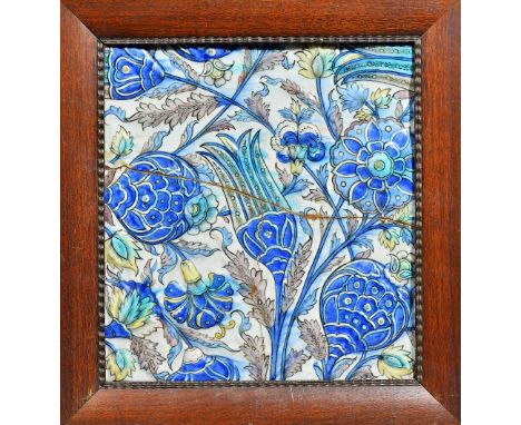 Three large Qajar pottery tiles in the Iznik style, 19th century,each moulded with carnations, pomegranates and a tulip in ma