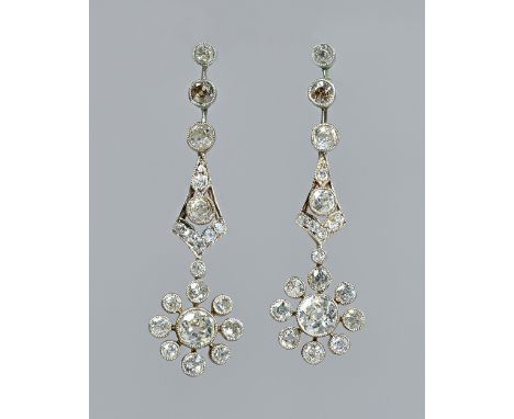 A pair of diamond set pendant cluster earrings, each cluster drop collet set with the principal cushion shaped diamond to the