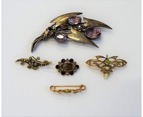 A gold, seed pearl and peridot set brooch, in a pierced scrolling design, detailed 14 K, a gold and seed pearl set brooch, de