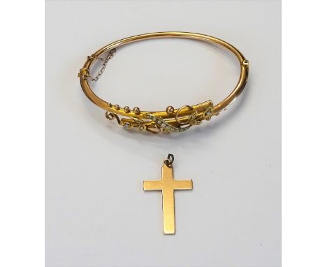 A gold and seed pearl set oval hinged bangle, the front in a beaded, foliate and scroll pierced cross over design, on a snap 