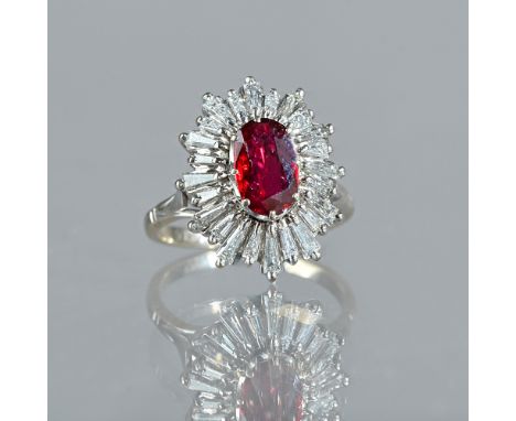 A white gold, ruby and diamond set shaped oval cluster ring, claw set with the oval cut ruby at the centre, within a surround