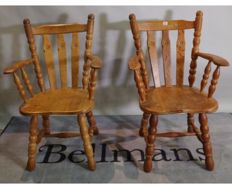 A set of six 20th century oak stick back dining chairs with carved floral motif on tapering turned supports, to include two c